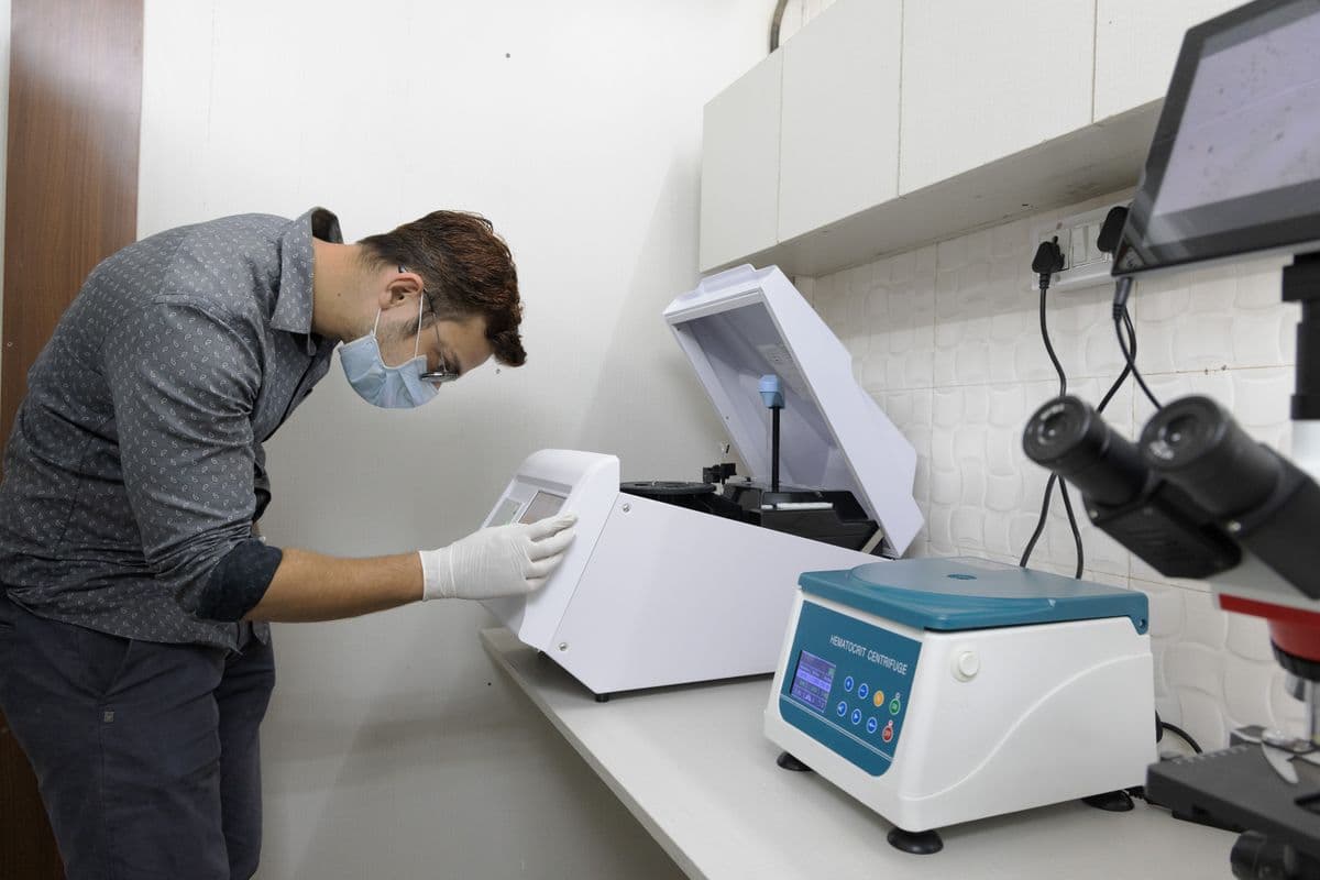 Wildlife Rescue technician operating hematocrit centrifuge and microscope in the diagnostic laboratory