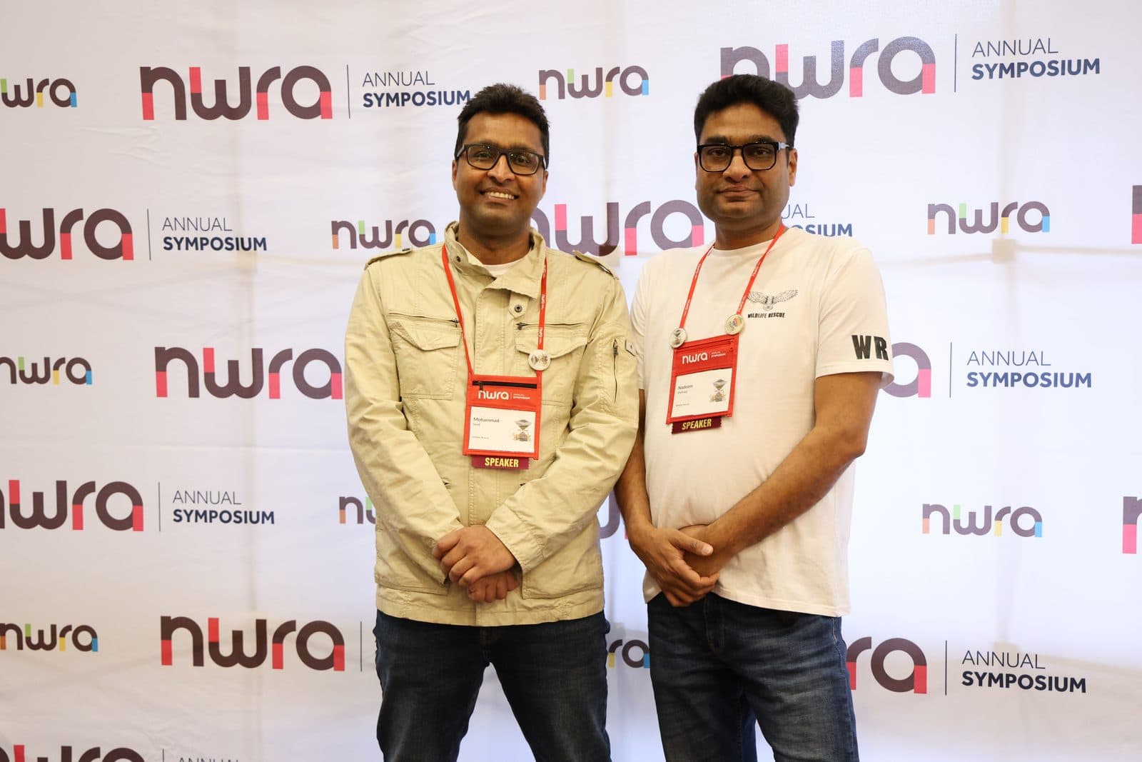 Nadeem Shehzad and Mohammad Saud of Wildlife Rescue wearing Speaker lanyards in front of the NWRA Annual Symposium backdrop, February 2025